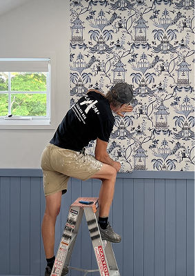 Grasscloth wallpaper installer on a ladder
